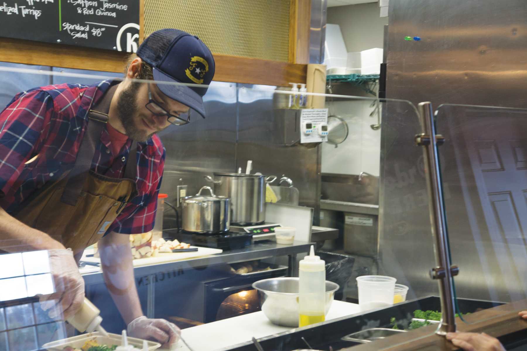 Will Crowell prepares one of Kindly Kitchen's made-to-order bowls. All food served is plant based and locally sourced.