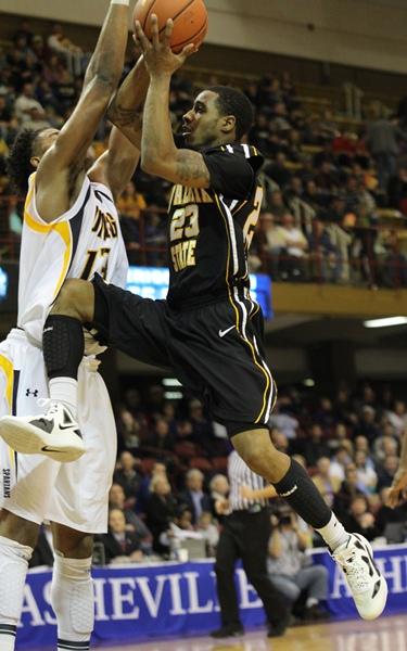 Freshman Mike Neal puts up a runner over senior Aloysius Henry in Appalachians 65-55 loss to UNCG in the second round of the SoCon tournament. Paul Heckert | The Appalachian