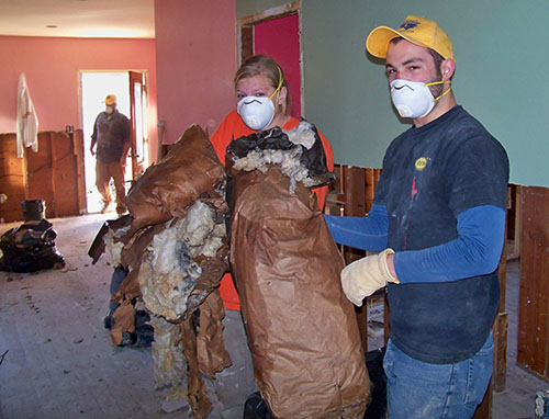 Sophmore social work major Mollie Jones and Sophmore chemistry major Nic McGuire remove moldy insulation from house affected by Hurricane Sandy.