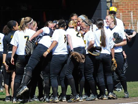 The softball team rallies after a win last season.