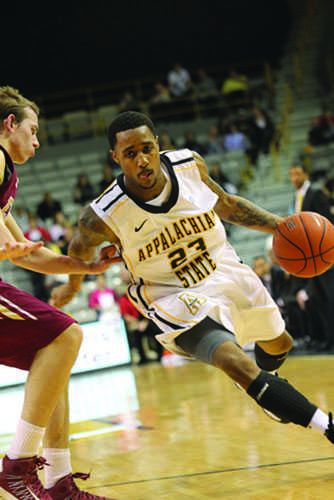 Sophomore guard Mike Neal maneuvers the ball around an Elon defender. Neal will return to play Thursday against Davidson after being sidelined for injuries.