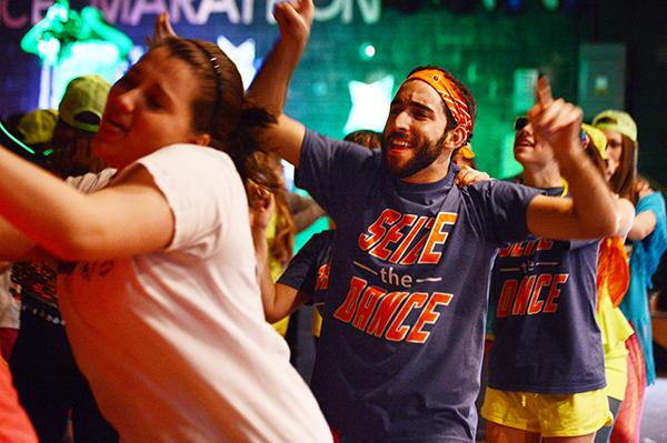 Junior risk management and insurance major Zach Yllanes throws his hands in the air during a congo line Saturday afternoon at Dance Marathon. The event took place in Legends for 15 hours and raised $26,530.98. Olivia Wilkes | The Appalachian