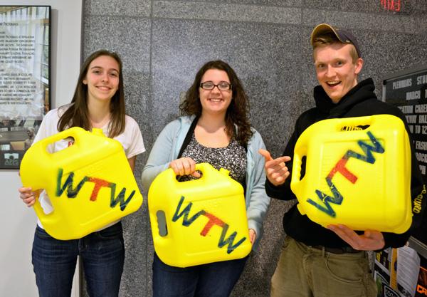 (Left to right) Ashley Ellis, Katy Cook and Michael John O’Neal are holding the Wine to Water jerry cans that will be carried in the walk Friday to raise awareness for the water crisis worldwide. Michelle Pierce