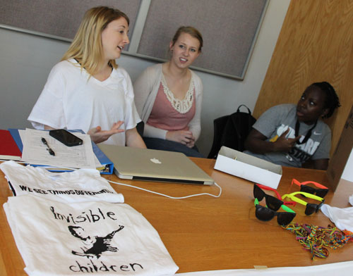 (L-R) Sophomore advertising major Colleen Ratigan, senior English major Stephanie Halchin and freshman advertising major Jelani Drew staff a contact table in Plemmons Student Union on Wednesday morning selling shirts in support of the Appalachian State Invisible Children Club. Paul Heckert | The Appalachian