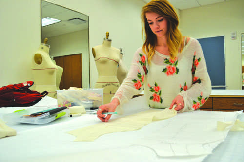 Junior apparel design and merchandising major Emily Renegar traces out material for the programs Spring Showcase this Saturday at 3 and 7 p.m. in Reich College of Education.