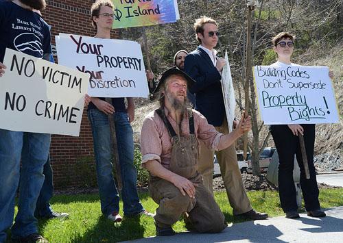 Owner of Turtle Island Preserve, Eustace Conway, speaks in front of the Watauga County Health Department surrounded by a group of supporters. A group of community members and students organized the march, which began at Sanford Mall. Olivia Wilkes | The Appalachian