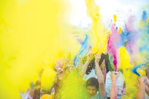 Participants in the first Tie-Dye Dash celebrate the end of the 5K-run by throwing leftover colored powder into the air. Proceeds from the event went to Appalachian and the Community Together and ASU Club Sports. Justin Perry | The Appalachian