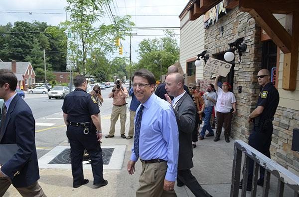 Gov. Pat McCrory leaves Mellow Mushroom on Friday while protesters and supporters stand outside. McCrory stopped by the pizza restaurant for a meet and greet after speaking at the second annual Appalachian Energy Summit at Appalachian State University. Michael Bragg | The Appalachian