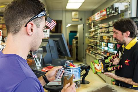 Junior economics major Chris Zino prepares to hand Kangaroo Express employee, Jesse Steele, his ID to purchase a six-pack of beer. Throughout the summer the Watauga Substance Abuse Prevention Collaborative has conducted compliance checks with local business to determine if they will provide underage persons with alcohol. Photo by Paul Heckert | The Appalachian