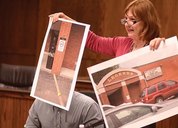 Member of the Watauga County Board of Elections Kathleen Campbell holds up photographs of the outside of Legends during Wednesday nights Board of Elections meeting. Campbell argued against the relocation of voting spaces to the nightclub instead of the student union. Photo by Maggie Cozens | The Appalachian