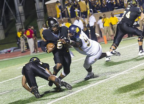 Sophomore Quarterback Kameron Bryant brushes off a tackle from an NC A&T defender in Saturday nights game. Despite a fourth-quarter comeback the Aggies held off the Mountaineers for a 24-12 win. Photo by Paul Heckert  |  The Appalachian