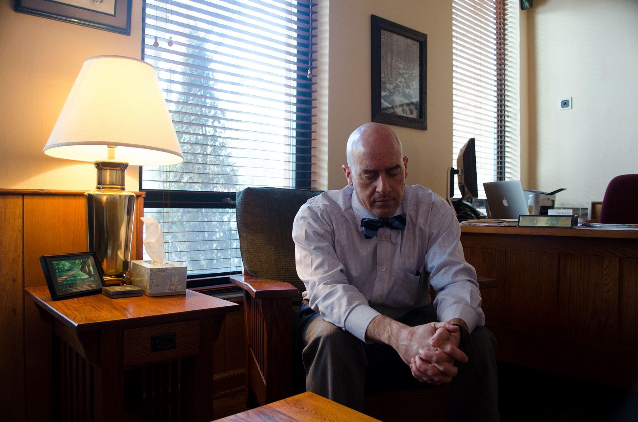 Dean of Students J.J. Brown is responsible for communicating with the families of students who pass away. When he’s about to reach out to them, he takes time to close his eyes, relax and think about how the family will react to the news they’re about to receive. Photo by Michael Bragg