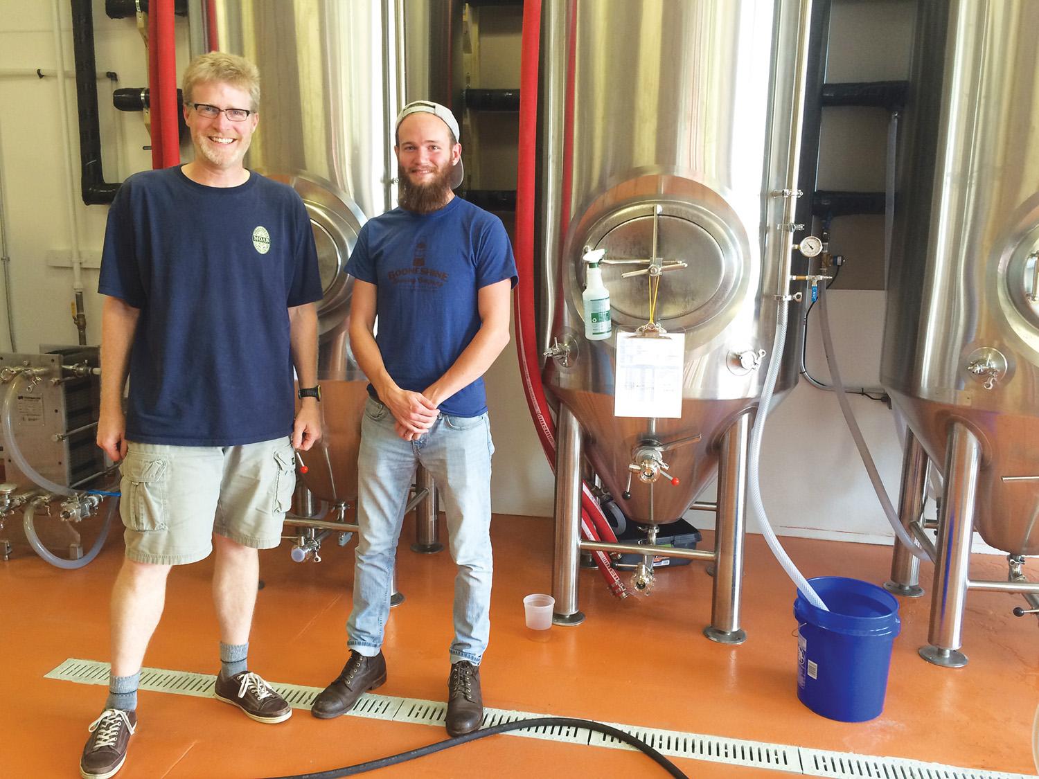 Tim Herdklotz, co-founder of Booneshine Brewing Co. and Garrett Williams, a volunteer at Booneshine, pose for a photo inside 

the new facilities. Booneshine Brewing Co., Boone’s newest brewery, opened on July 1.