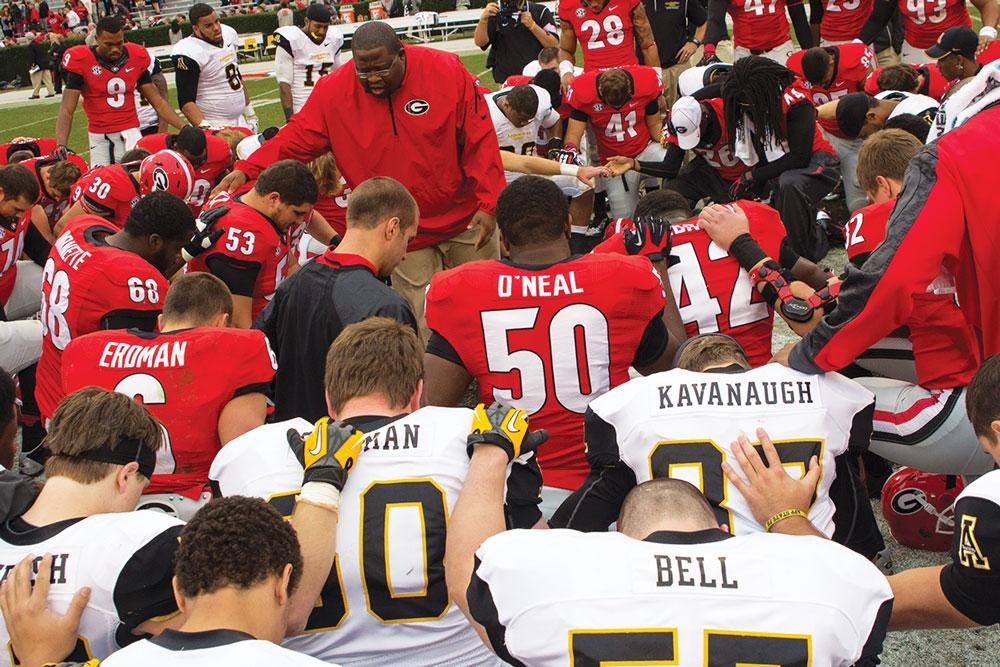 Director of player development for the Georgia Bulldogs John Eason leads both teams in prayer at the center of the field after the Mountaineers’ 45-6 loss in November. Win or lose, the Mountaineers tend to engage in post-game fellowship. Photo by Paul Heckert  |  The Appalachian