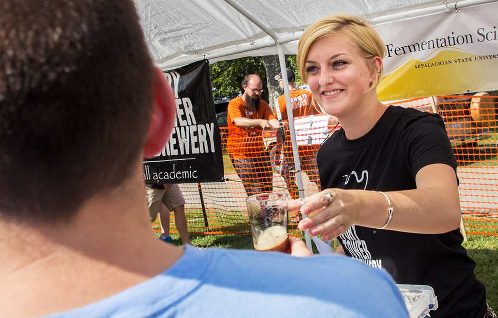Senior+fermentation+science+major+Emily+Williams+prepares+to+fill+a+thirsty+festival+goers+glass+with+a+Stout+Float+a+combination+of+stout+beer+and+ice+cream+
