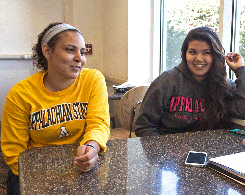 Freshman chemistry major Katie Sampson and junior exercise science major Savannah Bowen discuss the improvements in the Lumbee Native American community last Thursday in Trivette Dining Hall. Photo by Kelly Walker  |  The Appalachian