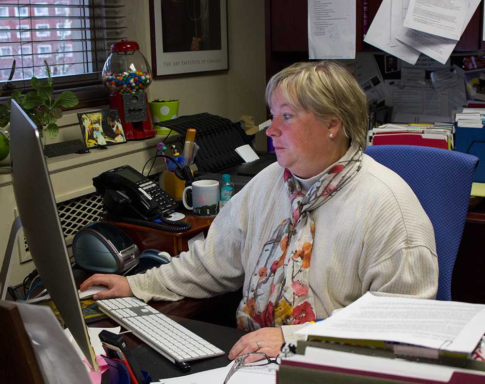 Associate Dean of the College of Arts and Sciences Neva Specht looks over work in her office. Photo by Dallas Linger  |  The Appalachian
