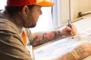 Greg Kinammon working on a painting in his new tattoo studio, part of Speakeasy Tattoo Co. on Friday afternoon. His new stuido is located on Kings Street near Capones. Photo by Halle Keighton  |  The Appalachian