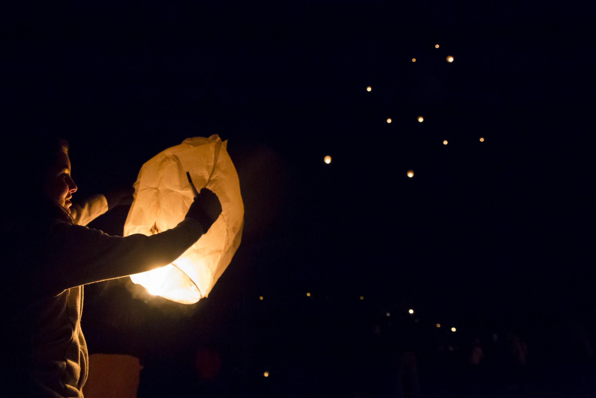 Sophomore communication science and disorders major Caroline Stottler releases a Chinese paper lantern Thursday night at the pavillion along the greenway in honor of Mandie Phillips, who died in a car accident in December 2014.