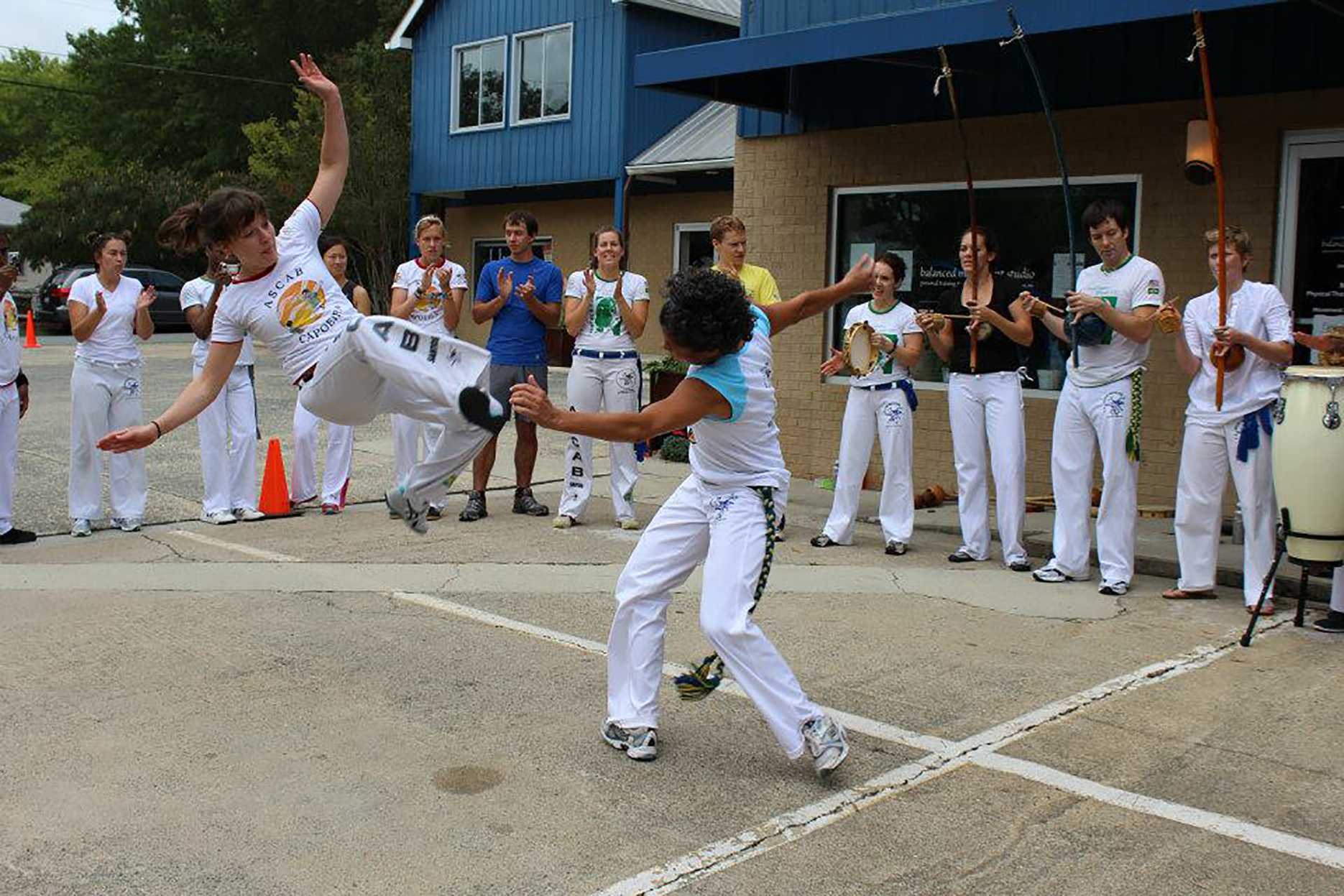 Appalachian Spanish lecturer and capoeirista Gabriella Motta-Passajou (right) and her students perform the Brazilian fight-dance Capoeira in an open roda.