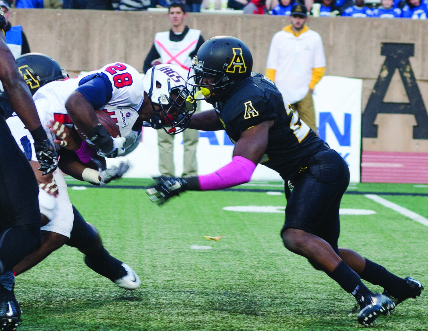 Defensive back Joel Ross prepares to put down a South Alabama University Jaguar at a football game at Kidd Brewer Stadium.