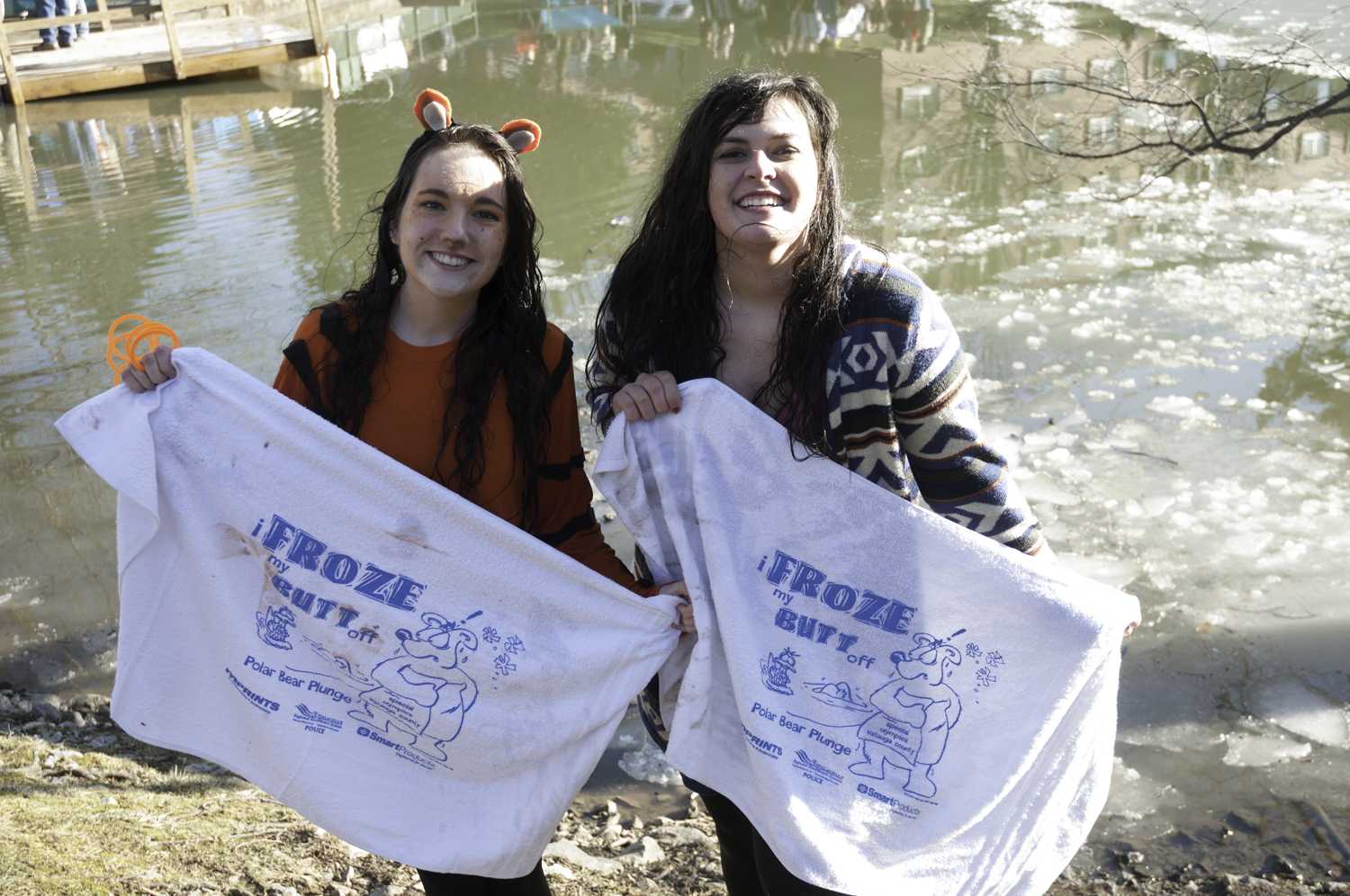 (Left to right) Danielle Davis and Moriah Voorhis pose with their Polar Plunge towels after diving into Duck Pond. Danielle won the contest for best female costume. Photo by Brandon Peterson.