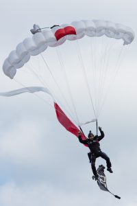 One of the three skydivers preparing to land onto the field. 