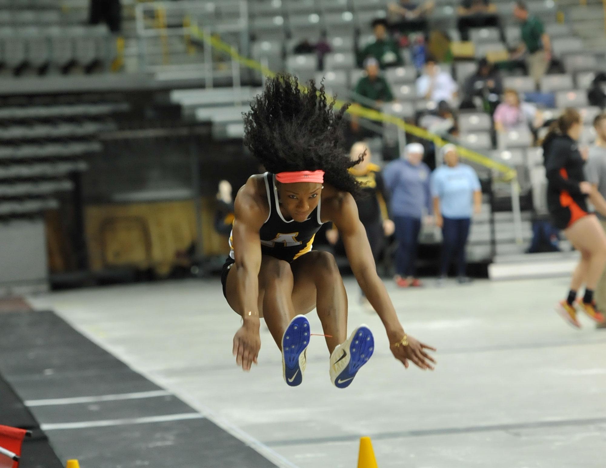 Junior Chelsey Hargrave jumps in the long jump during an indoor home track meet.