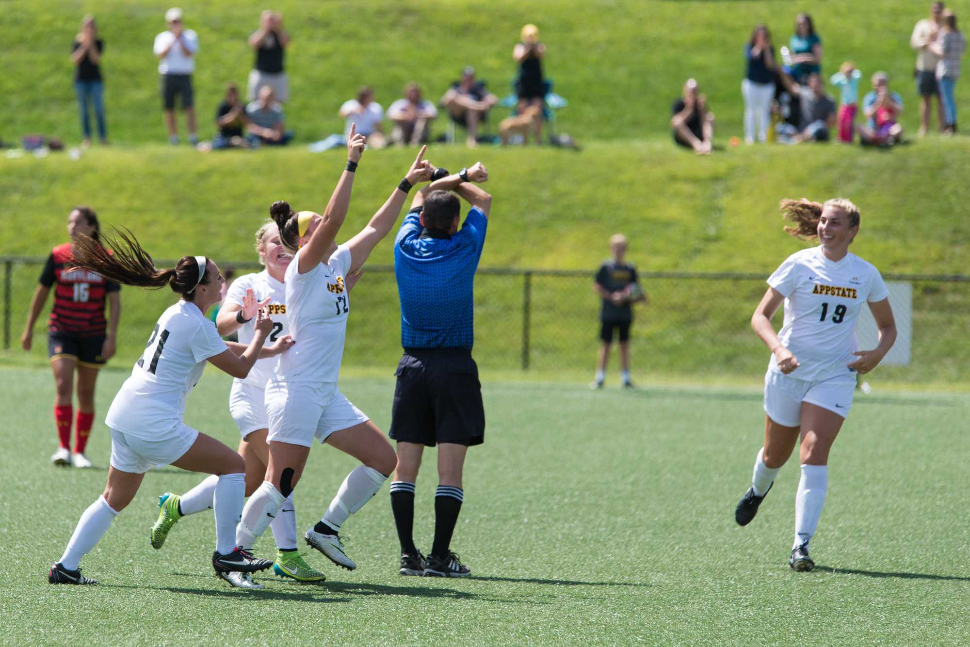 Senior defense #21 Aubrey Fletcher, junior midfield #20 Morgan Mosack, redshirt sophomore forward #12 Erin Settle and sophomore midfield/forward #19 Emmily Cowie celebrate Settles goal against Maryland. Settle scored the teams first goal of the game in the second half. Photo by Dallas Linger, Photo Editor