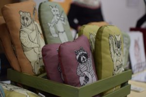 Handmade pillows for sale at the Siamese Bean table in the Handmade Market during the Fiddler's Convention.