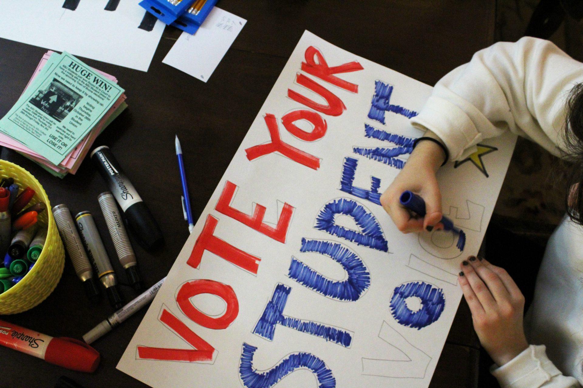 Amanda Lago, a sophomore anthropology major and member of the Watauga County Democratic Party, making a sign to celebrate securing an on-campus voting site for App State students at the partys headquarters on Oct. 25. After a battle in the courts, App students were granted a polling place for the municipal election on Oct. 25. 