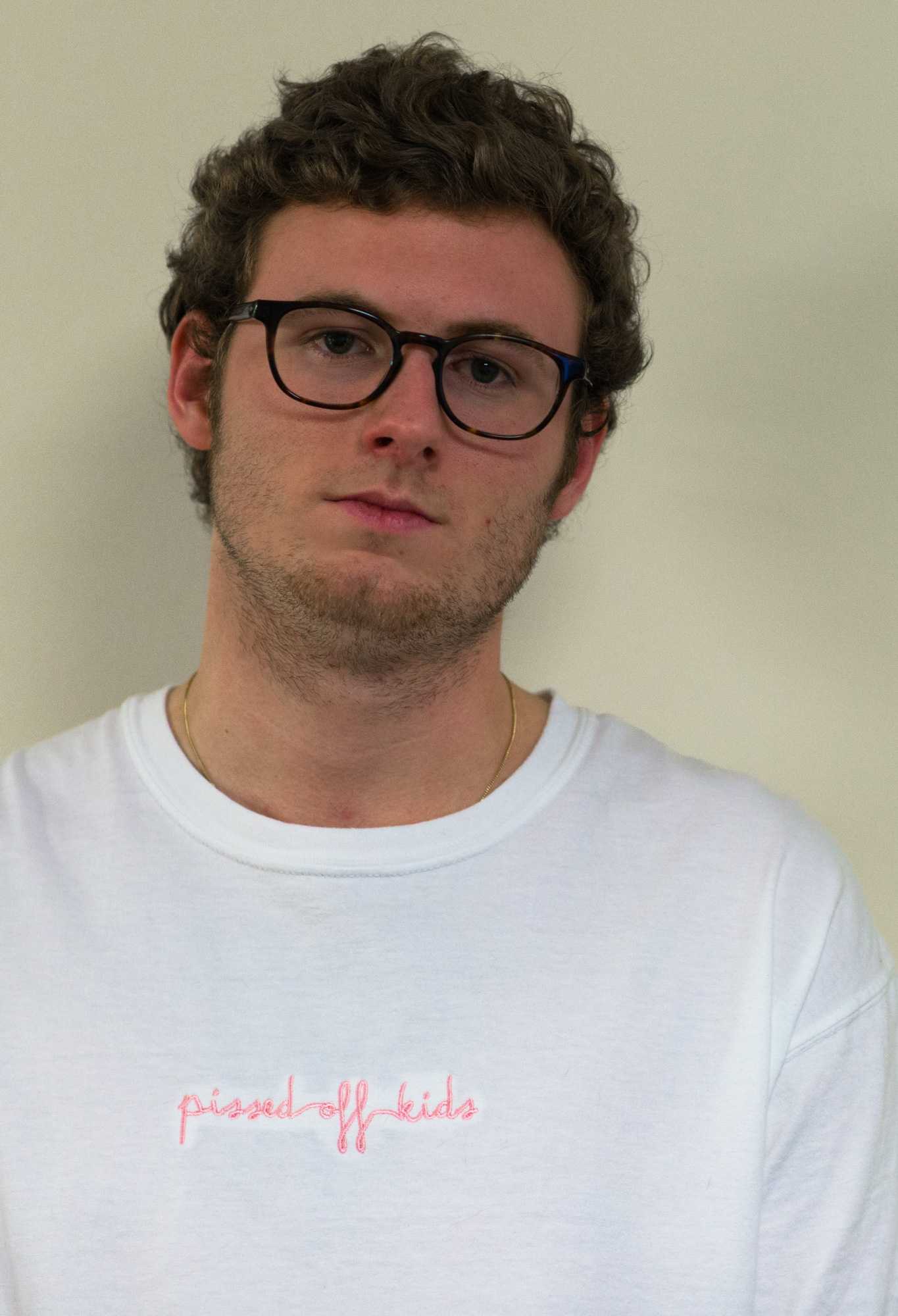Senior communication/journalism major Hunter Greer wears a white Pissed Off Kids t-shirt. Pissed Off Kids t-shirts come in white, pink, blue and black, all with pink stitching. Photo by Dallas Linger, photo editor.