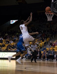 Freshman forward Isaac Johnson attempts to score with a layup during the game against UTA. 