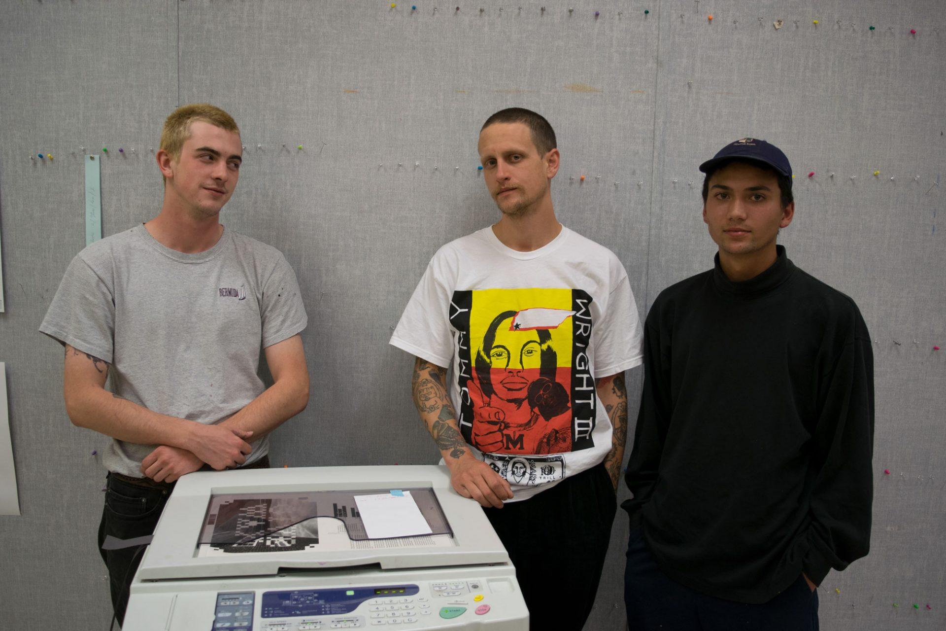 David Vertrees (left), Jason Wright, and Julien Passajou pose in front of the risograph printer in Wey Hall.