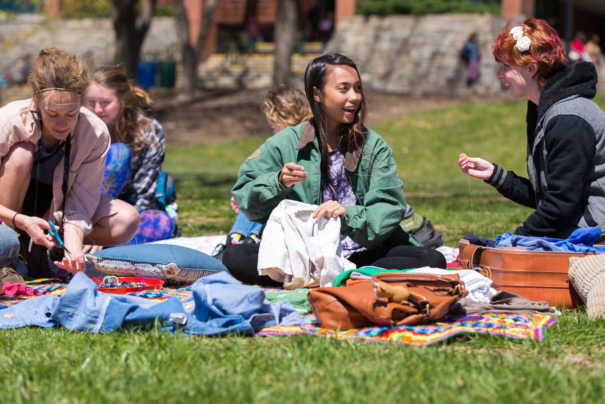 (Left to right) Event coordinator Audrie Emma Bruce, Rachel Sanders and Logan Land sew buttons ("nipples") on t-shirts on Sanford Mall Tuesday afternoon. Photo by Dallas Linger.