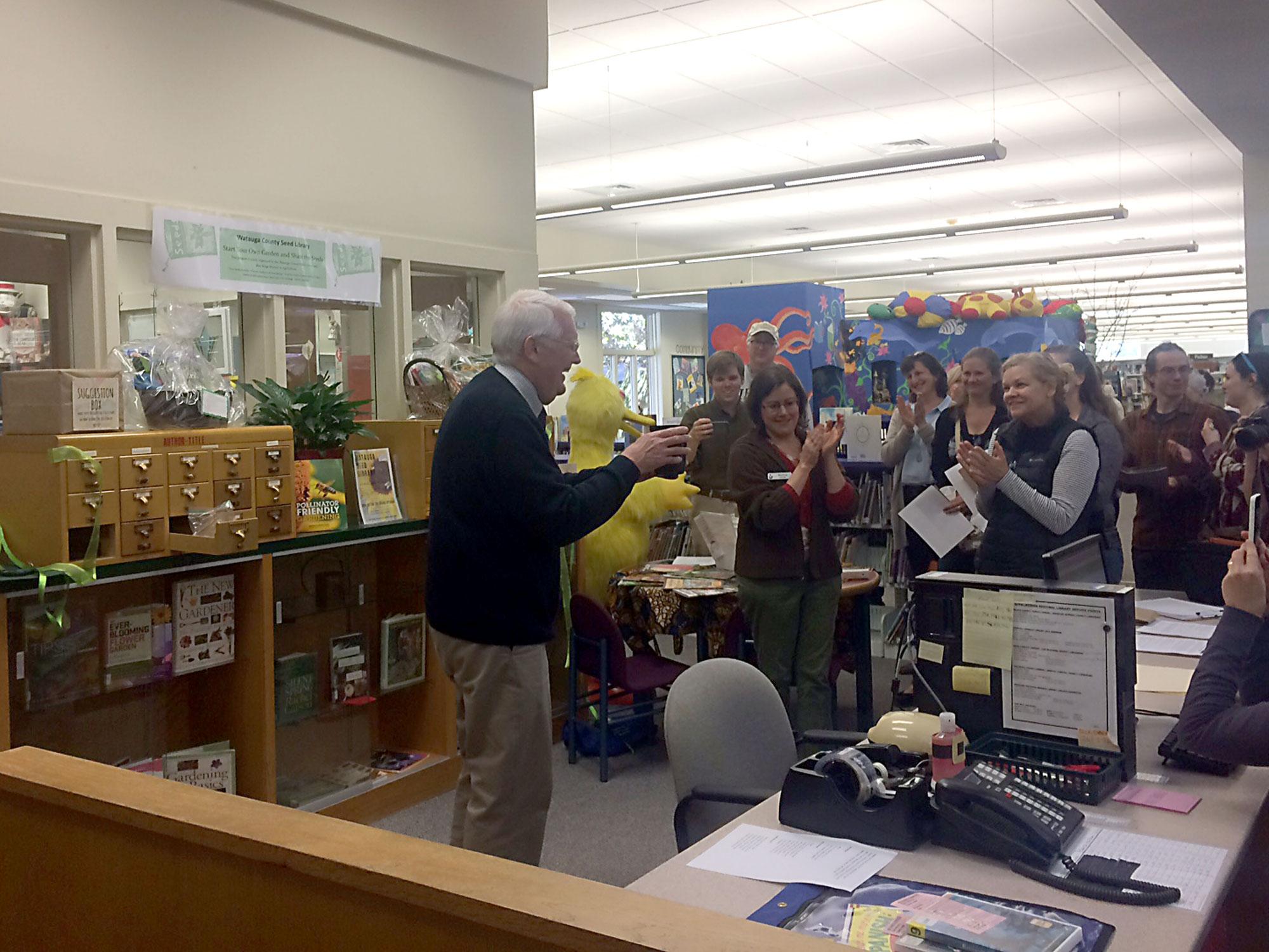 Mayor Rennie Brantz plants a sunflower seed after cutting the ceremonial ribbon at the grand opening of the seed library on April 1. The seed library provides over 100 seeds, free for the public to check out. 