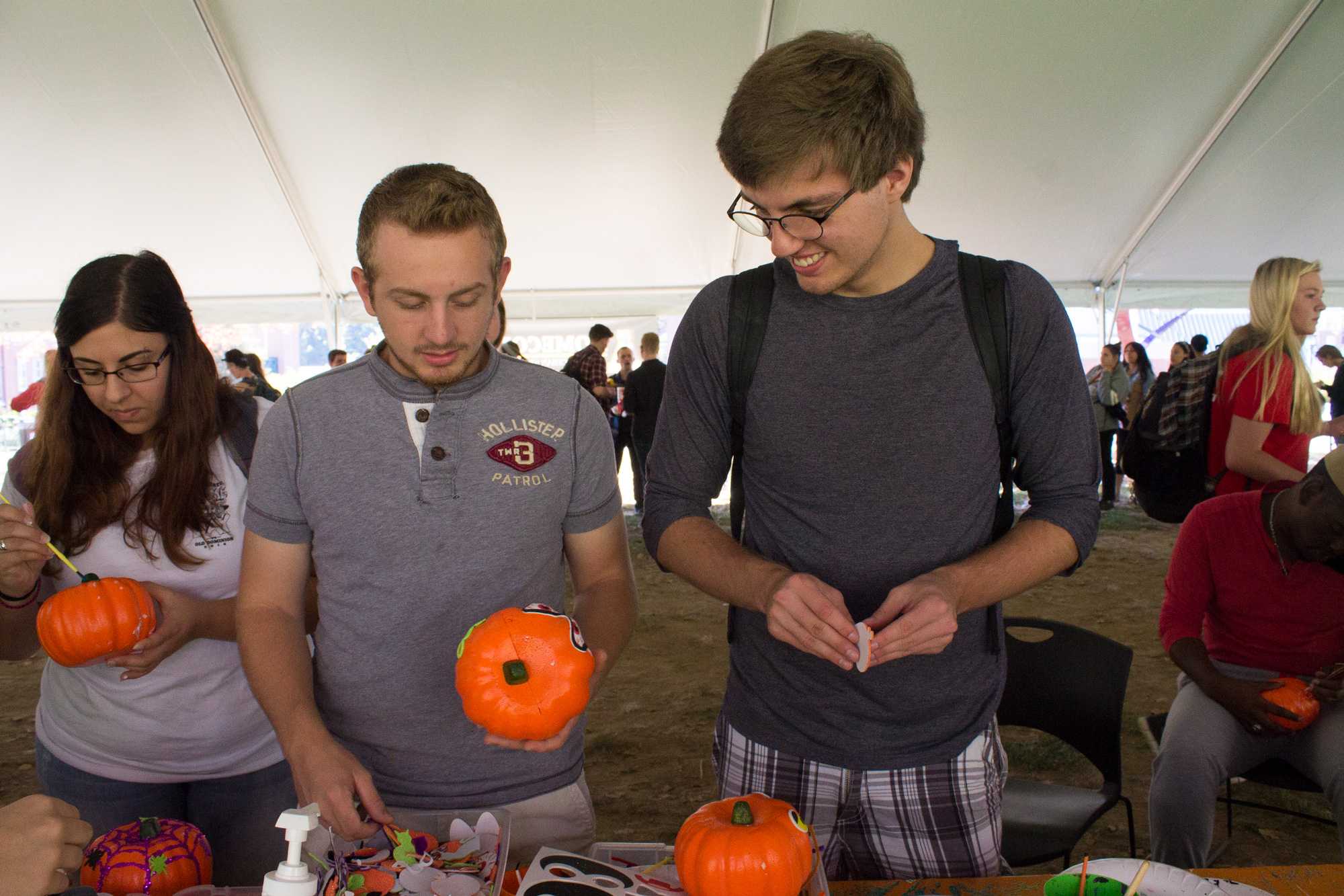 Freshman Ben McGuire (left) and junior psychology major Logan Ellis (right) put stickers on pumpkins for Mountaineer Spirit Day on Oct. 19.