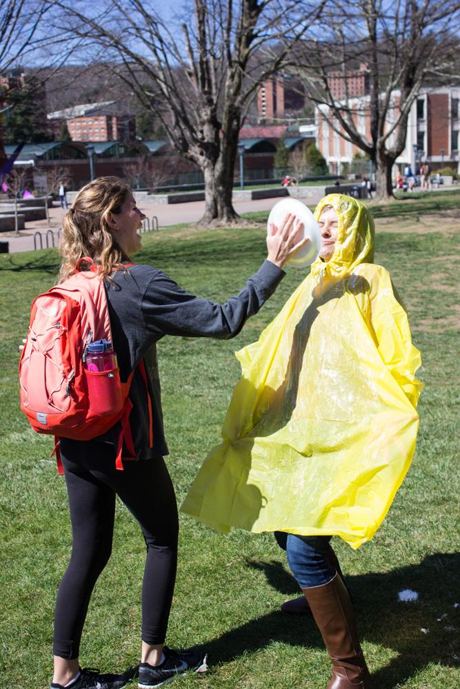 A student throws a pie in Dr. Jennifer Dalton's face. Pie-A-Professor happened on Friday, March 18th on Sanford Mall. The event helped raise money for the NC School for the Deaf and the ASL Club. Students could sign up for certain times to pie professors. Photo by Halle Keighton.