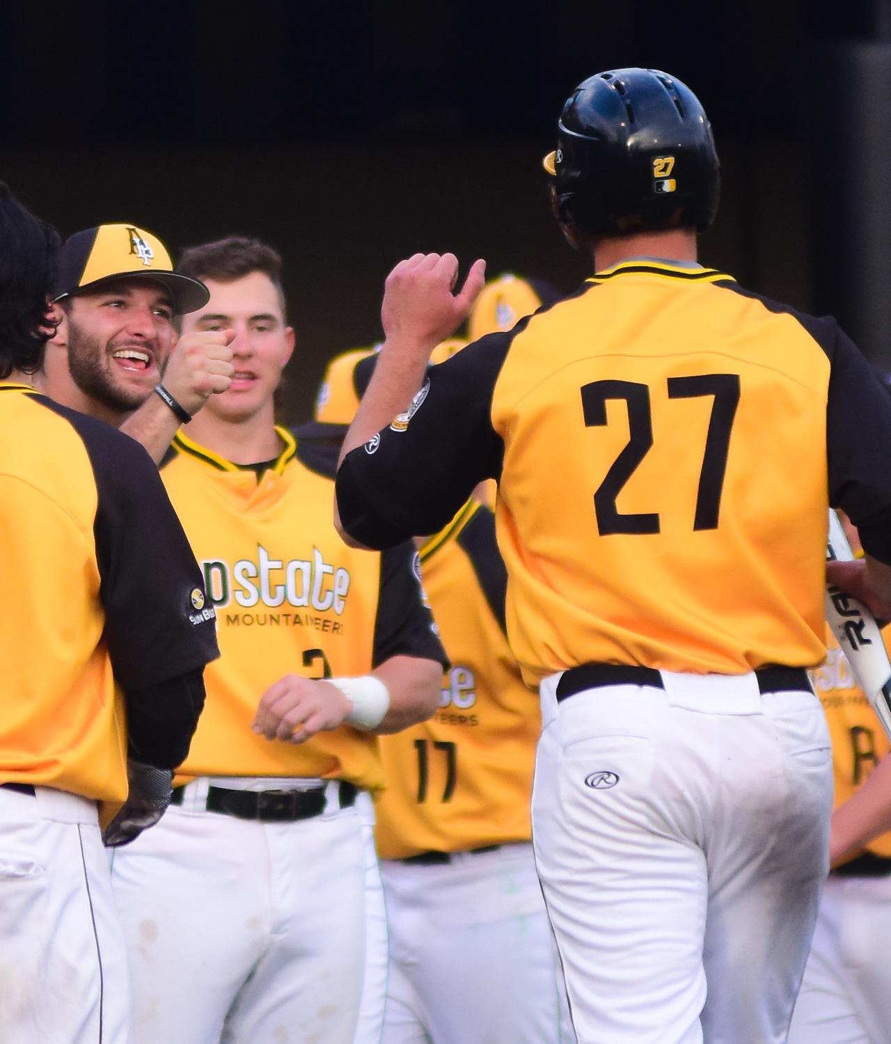 Senior infielder Grayson Atwood returns to the dugout and celebrates with senior right-handed pitcher and infielder Caleb McCann after making a run to home plate. Photo by Dallas Linger, Photo Editor