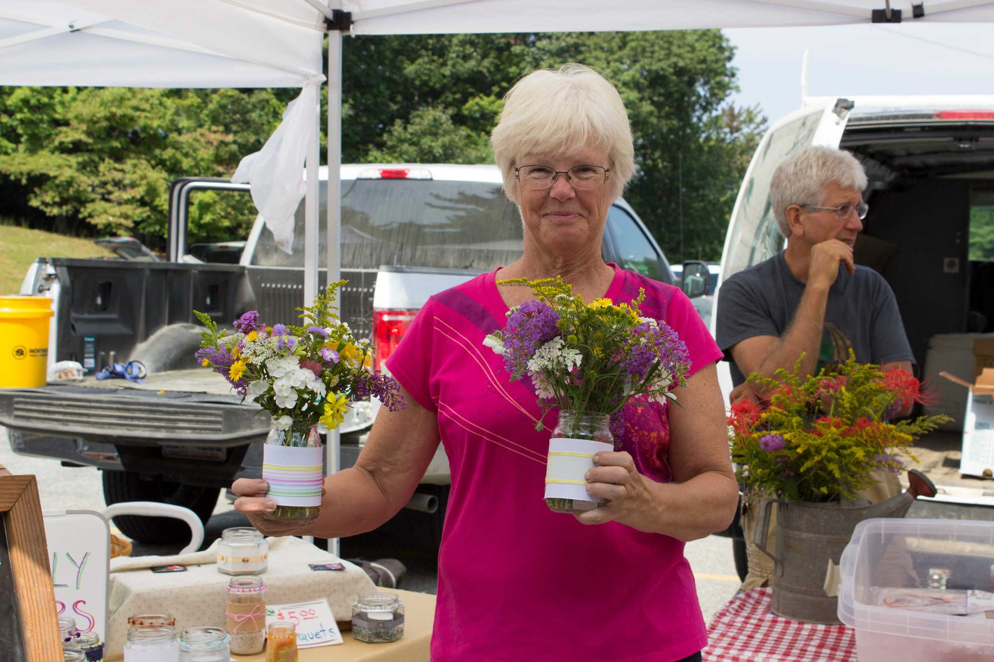 Lori Bryk, mother of Cory Bryk who started New Life Farm in Lenoir, NC helps her son and his family during the Farmers' Market. Bryk passes out a bouquet of flowers to a random person each Saturday.