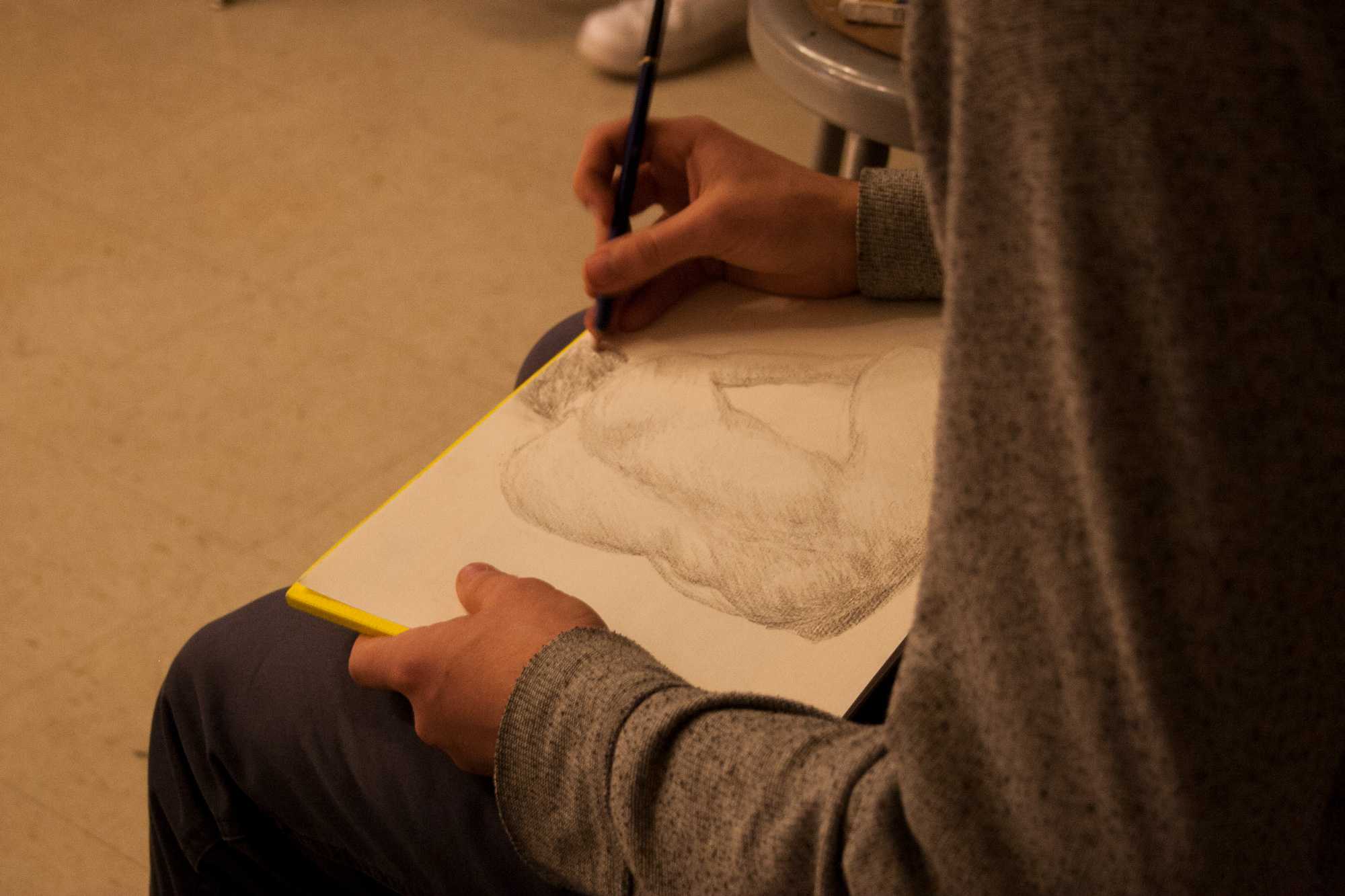 Sophomore, Seth Pray, draws a nude model. A figure drawing session was held in Wey Hall on Friday, November 11th. Students could sign up and come in and draw a live nude model to practice their skills.