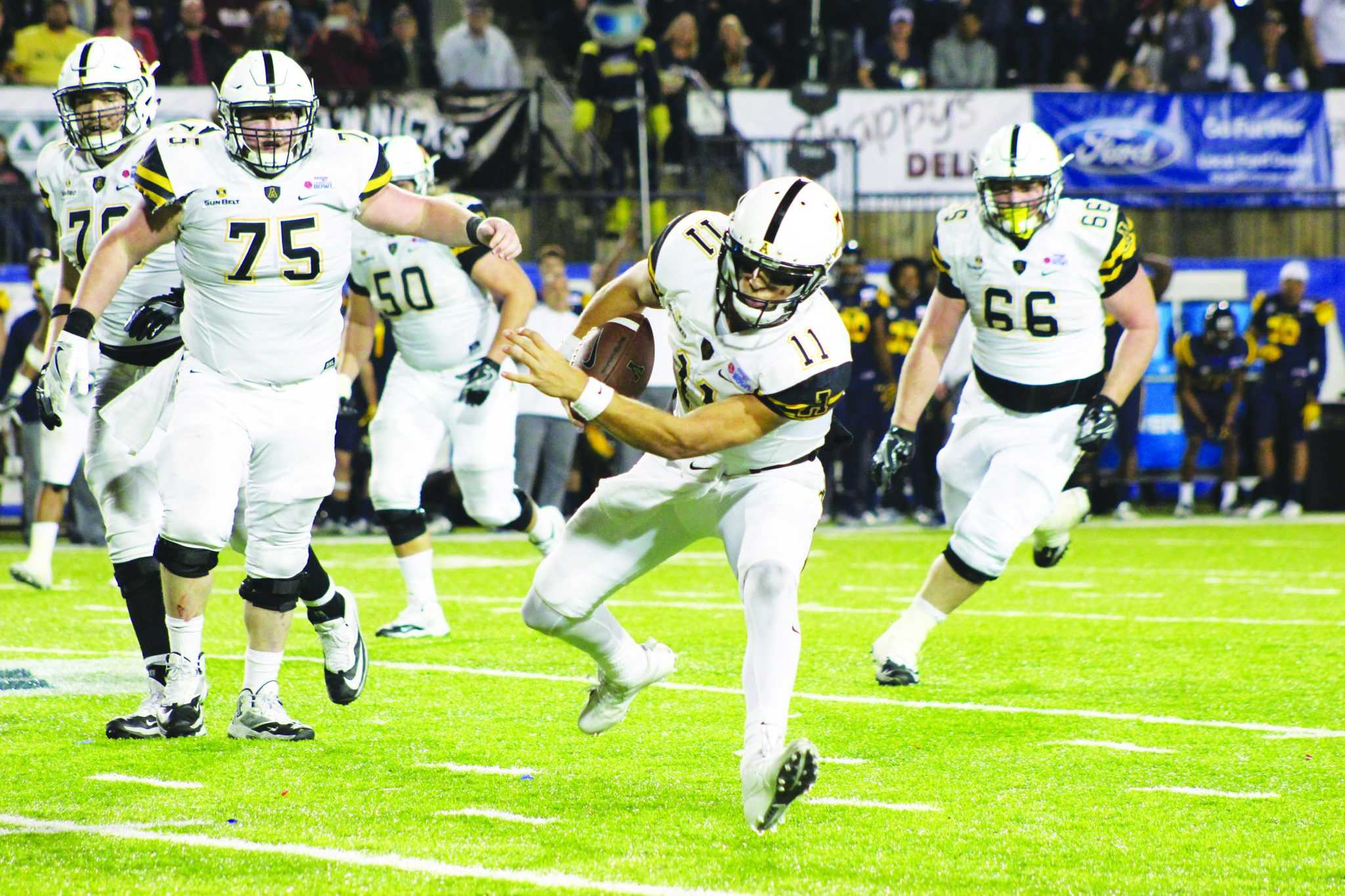 Junior Quarterback, Taylor Lamb, runs the ball down the field during the Camellia Bowl game against Toledo in Montgomery, Alabama. The Mountaineers won the game with the score being 31-28.