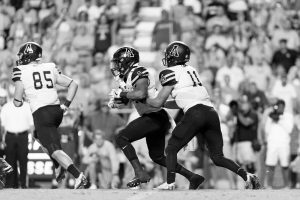 Junior quarterback Taylor Lamb passes the ball to senior running back Marcus Cox.