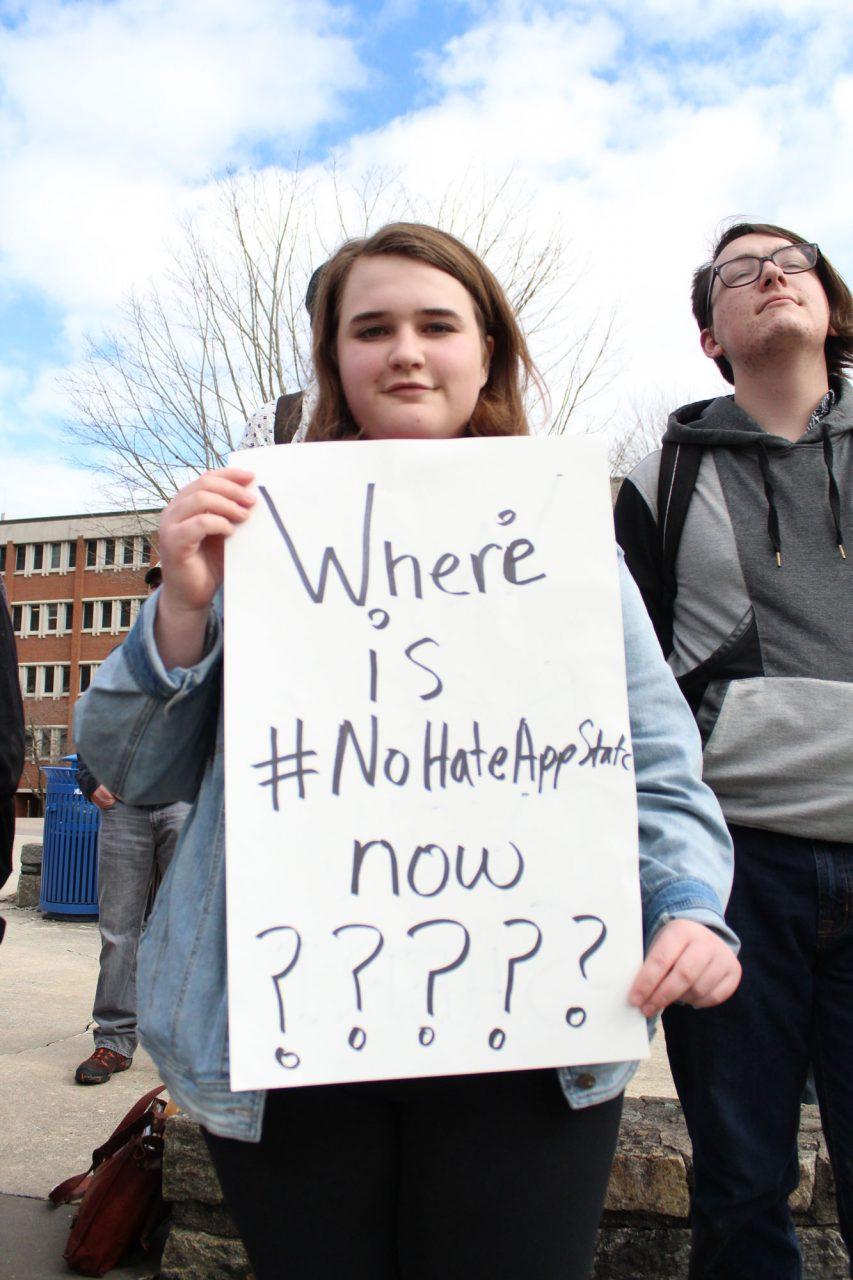 Freshman VP of College Democrats Maggie Behm holds up her sign at the protest against Speaker Michael Brown on Tuesday afternoon. Students gathered between the student union and the library to begin their walk around campus. 