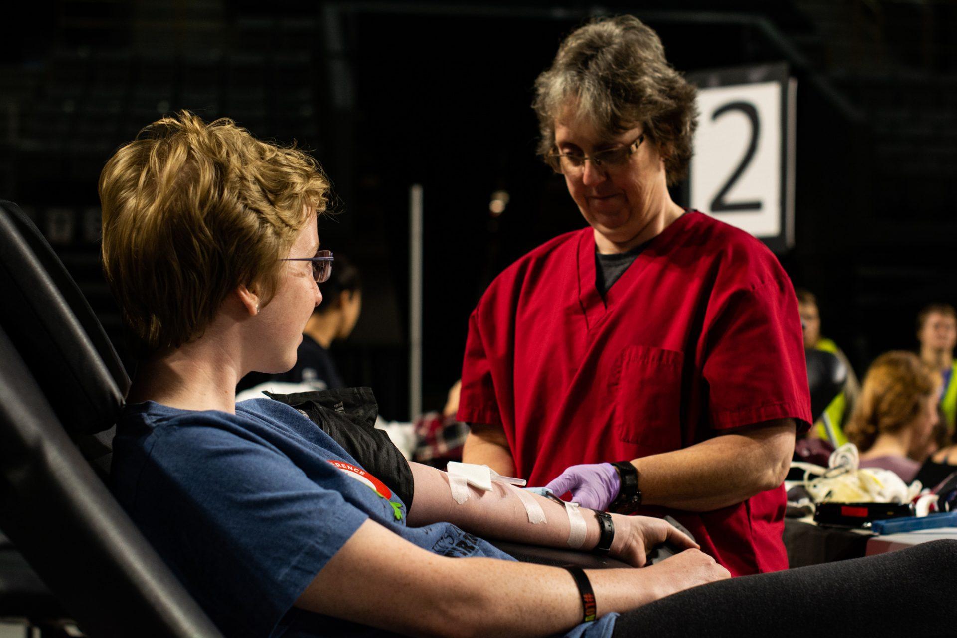 Environmental Science major Lara Chapman is assisted by a nurse while donating blood.