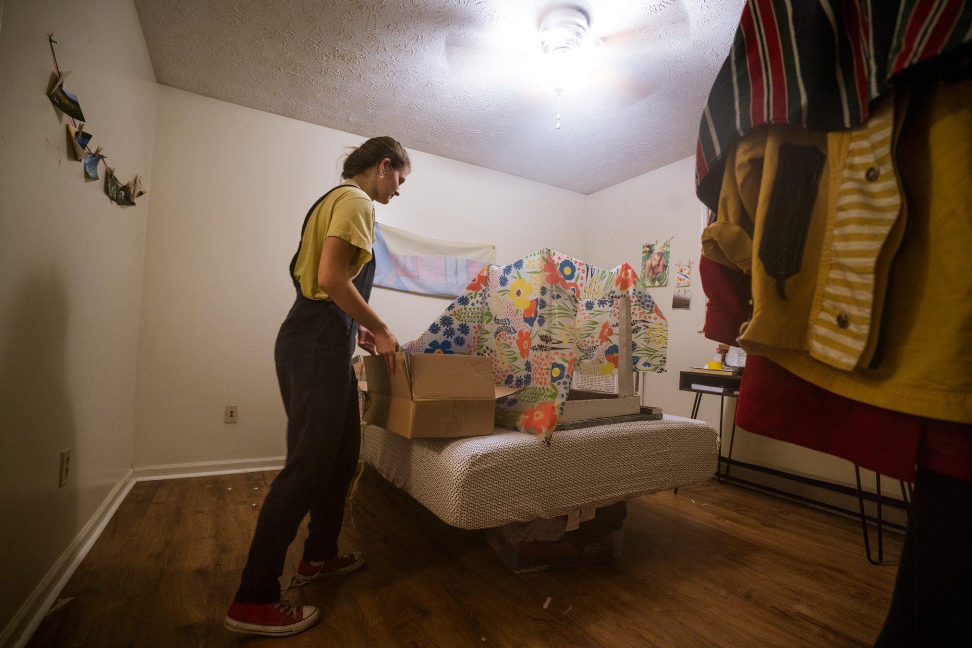 Sophomore Mericlaire Williams clears her bedroom floor before evacuating her flood-prone apartment Friday night. 
