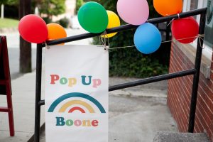A sign for Pop Up Boone displayed outside of Third Place. 