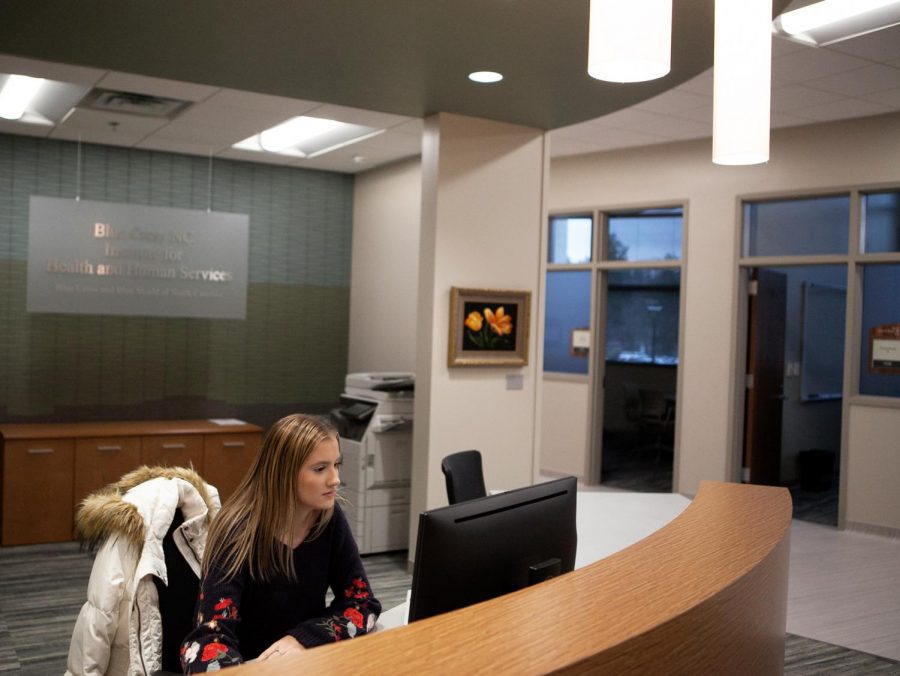 First year nutrition graduate student and graduate assistant of the Institute for Health and Human Services, Ashlyn Greene, works at her desk in the new IHHS clinic. The clinic is located in Leon Levine health sciences building. // Photo by Mickey Hutchings 