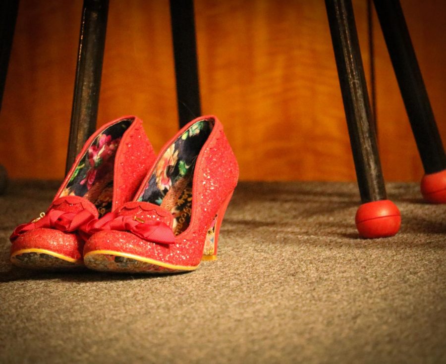 A cast member leaves her bold, bright red heels onstage during intermission. The audience bought t-shirts and vagina lollipops during the 10 minute break.