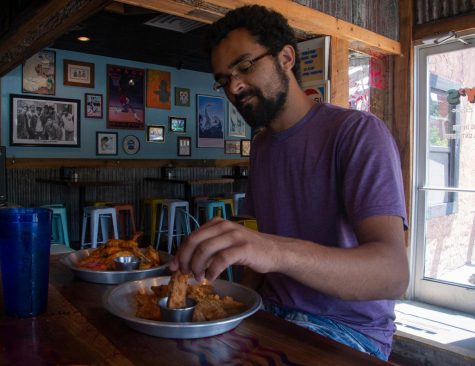 Senior Studio Art major Kelsey Ramsue enjoys some wings and potato wedges at Lilys Snack Bar. The new restaurant is located across from Durham Park on Hardin Street.